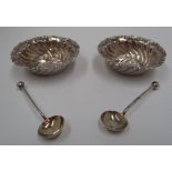A pair of Victorian circular silver salts with wrythen embossed sides and scroll border and