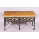 An Edwardian ebonised duet stool with hinged seat over fretted sides and on carved square legs