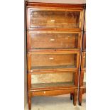 A four section Globe-Wernicke oak bookcase with glazed panel doors on a base with square tapered