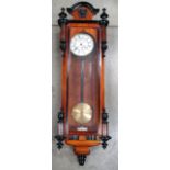 A German movement wall time piece in a walnut and part ebonised glazed case, with enamel dial,