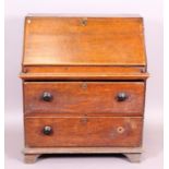 An early 19th century oak bureau with fall flap enclosing drawers and sliding panel,