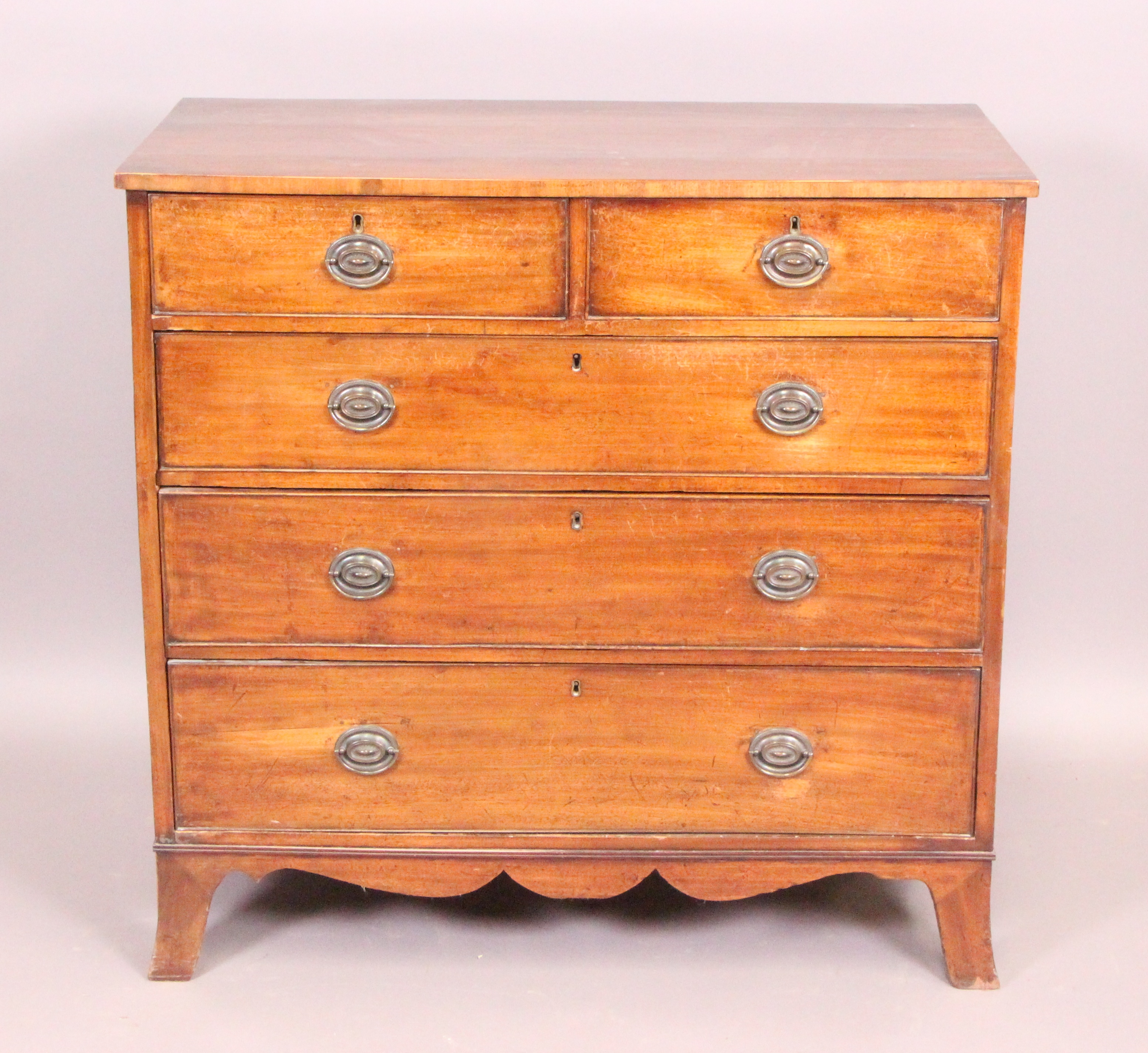 An Early 19th Century mahogany chest of two short and three long drawers on out-curved bracket feet