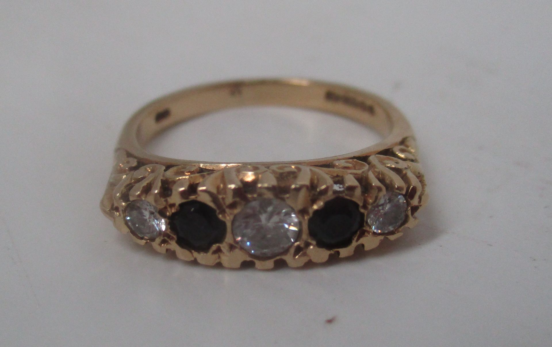 An 18ct gold ring set with 3 diamonds and 2 black coloured stones (total approx weight 4.