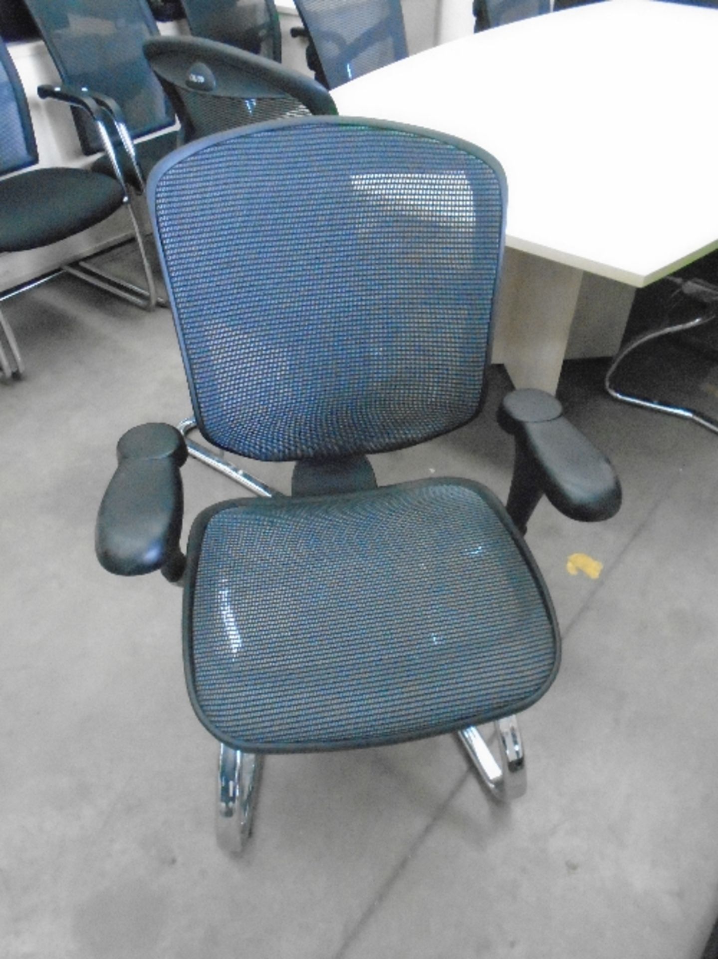 An Enjoy black upholstered boardroom chair with netted support back and adjustable arm rests on