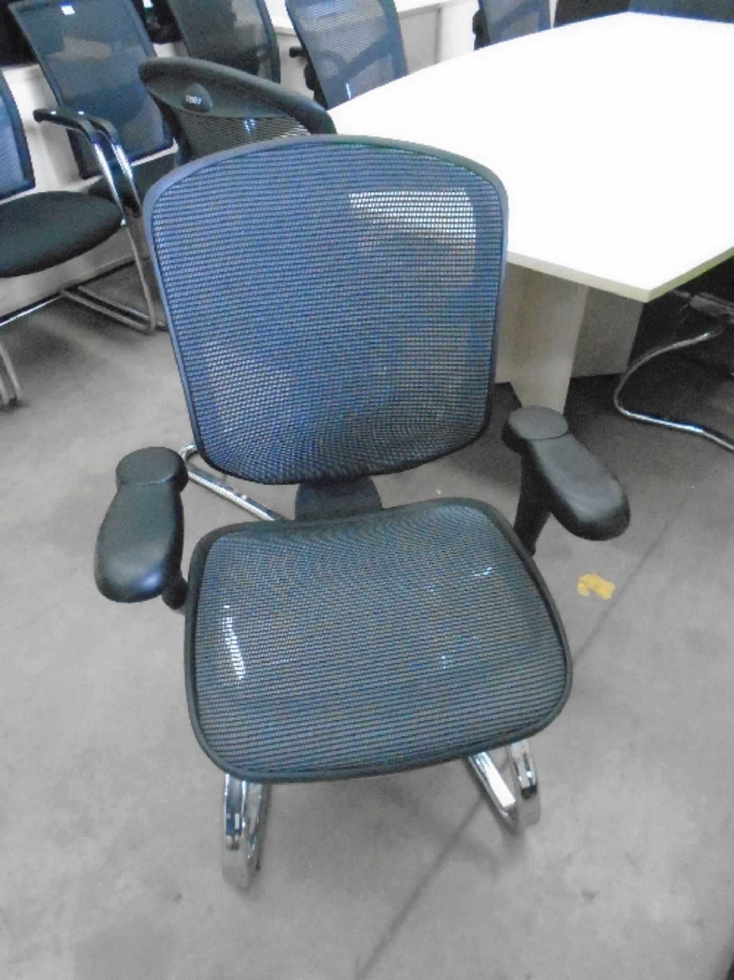 An Enjoy black upholstered boardroom chair with netted support back and adjustable arm rests on