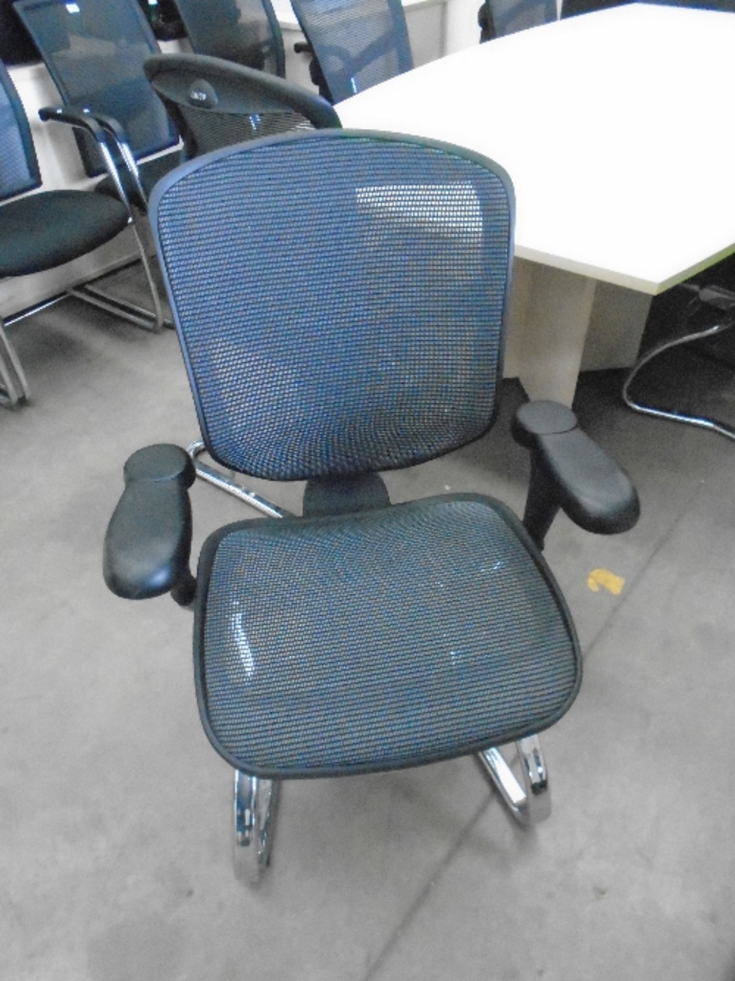 An Enjoy black upholstered boardroom chair with netted support back and adjustable arm rests on