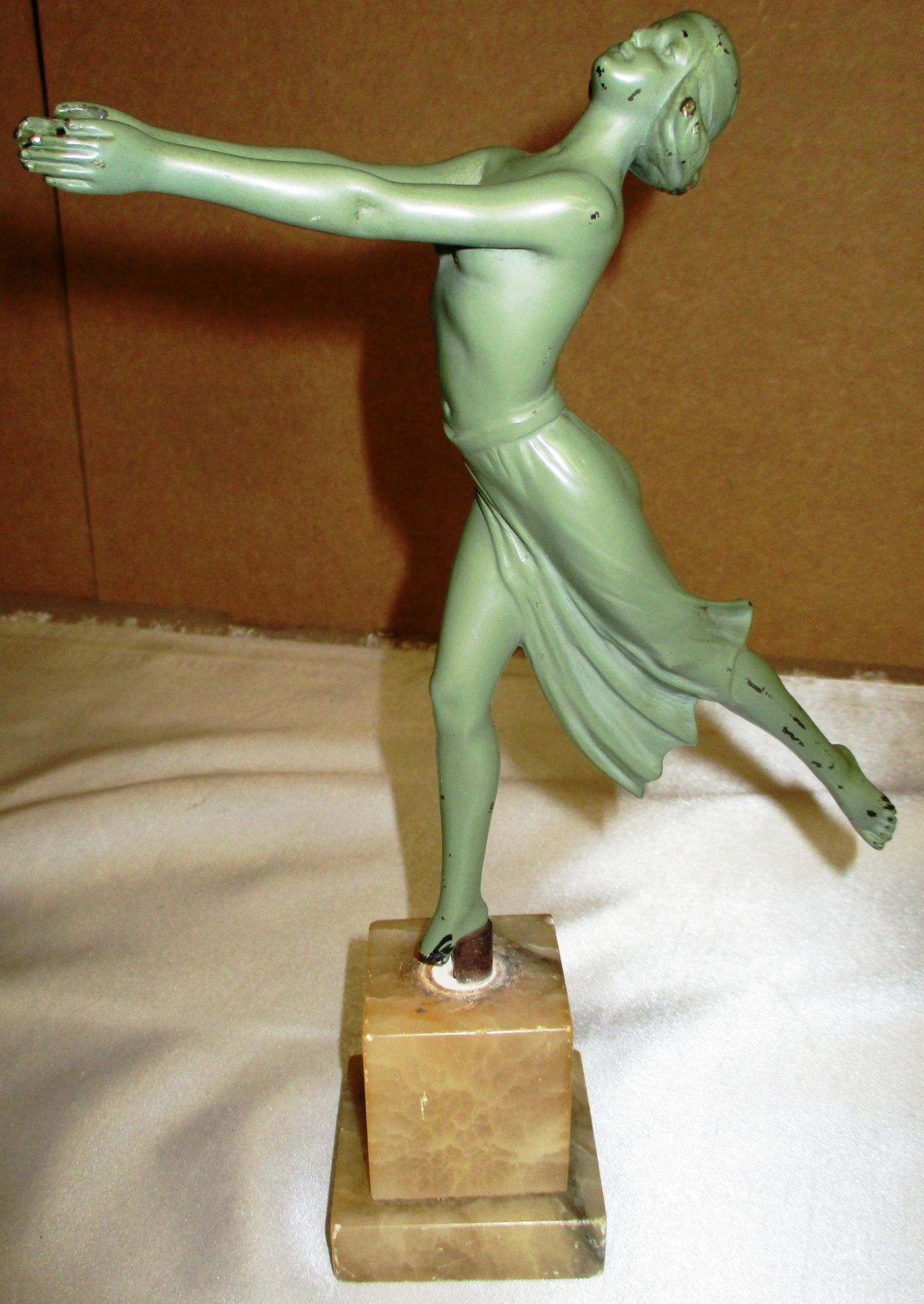 A green painted metal Art Deco figurine on Onyx stand (damage to standing foot)