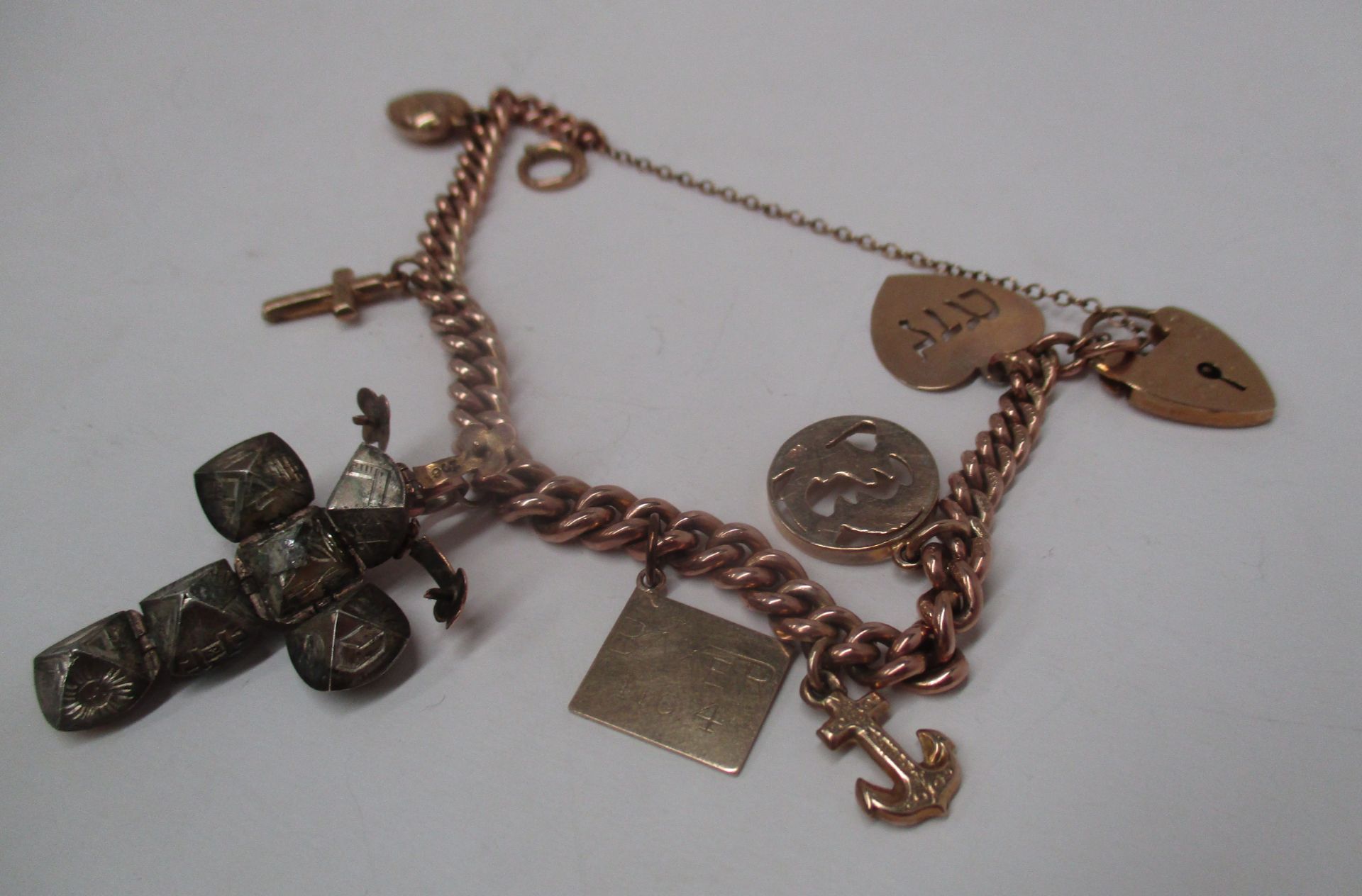 A 9ct gold charm bracelet with a quantity of 9ct gold charms including a Masonic ball/crucifix