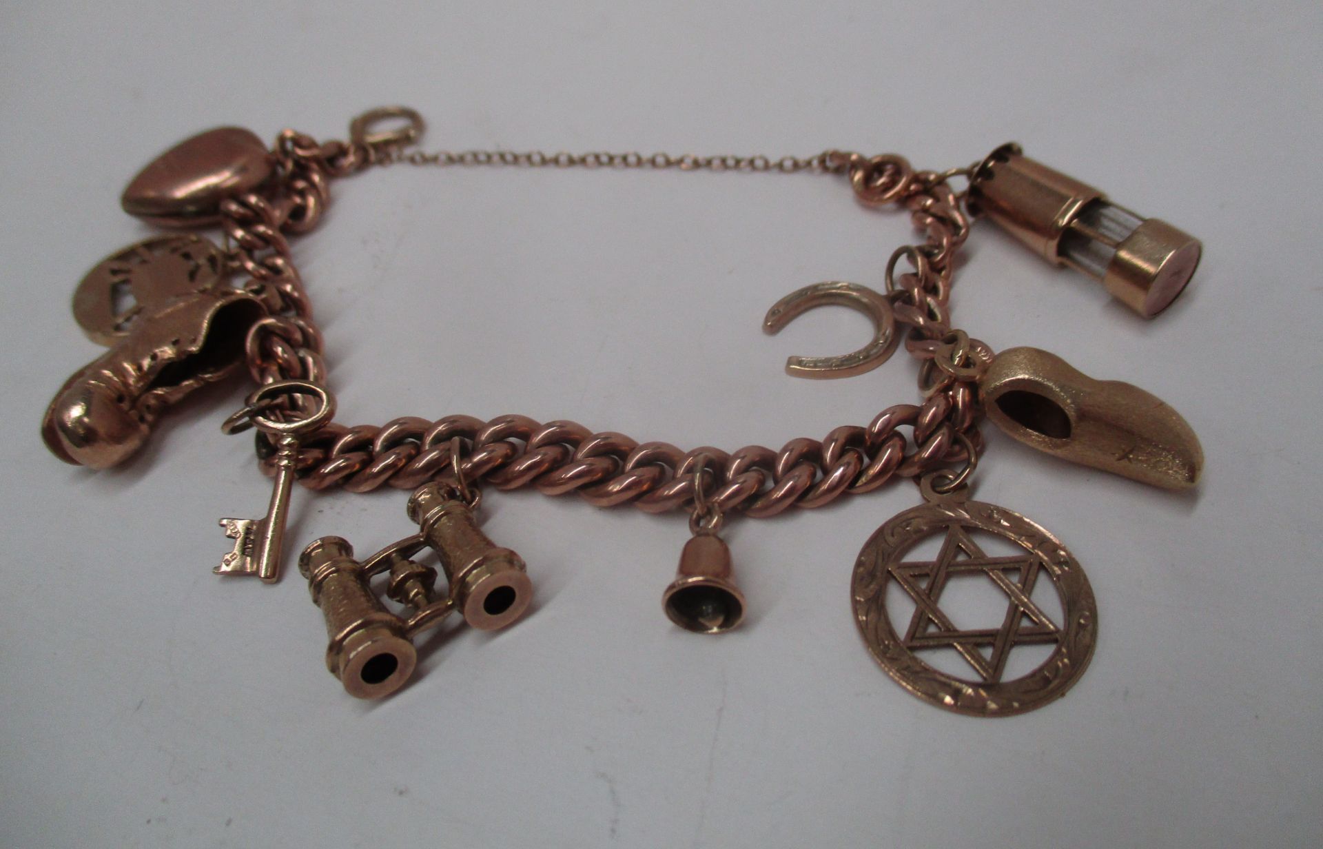 A 9ct gold charm bracelet with a quantity of 9ct gold charms (total approx. weight 32.