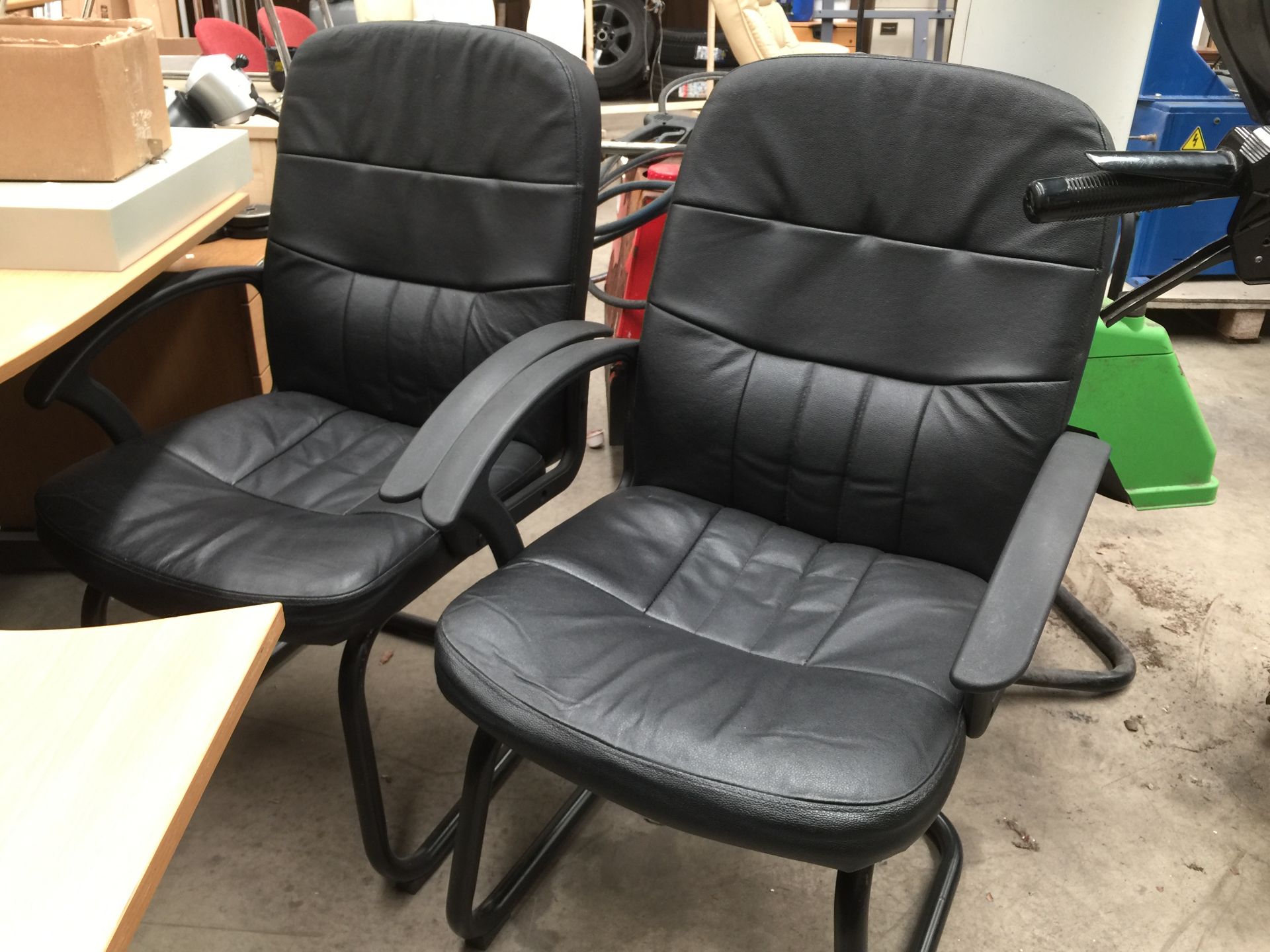 2 x black leather finish upholstered armchairs on black metal frames