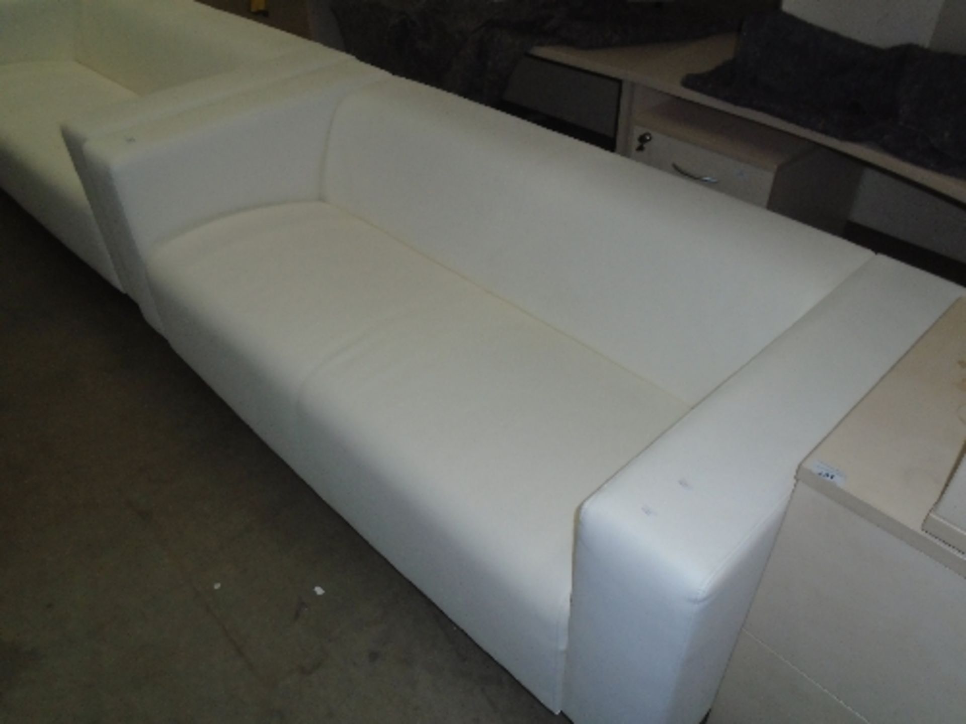 An Ikea white leather finish three seater settee on metal feet