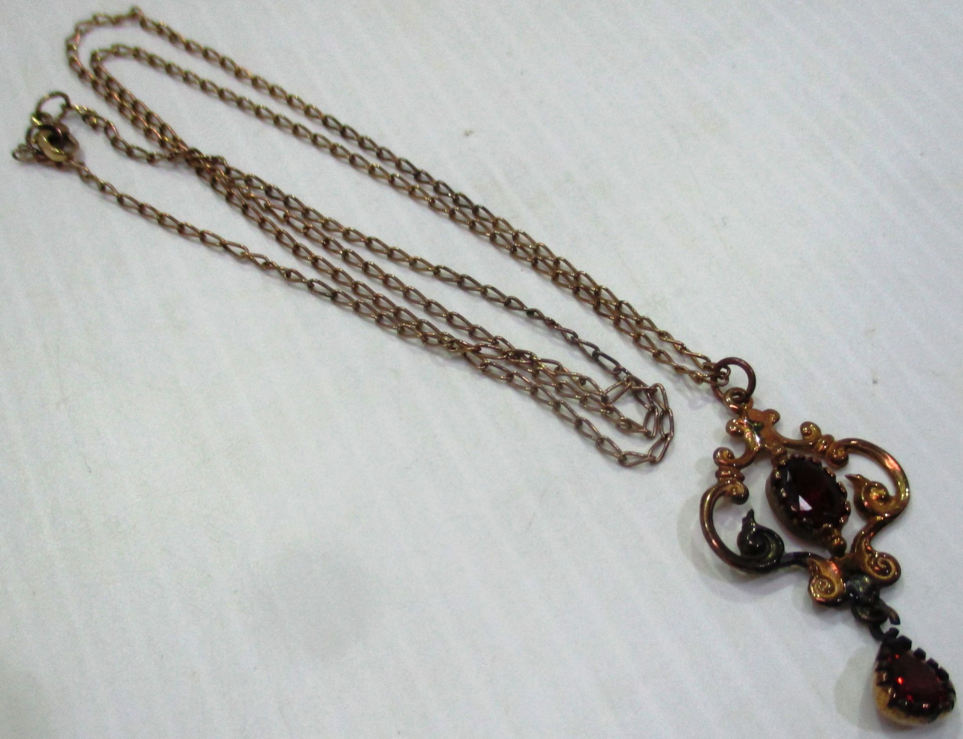 A fine 9ct gold neck chain with a 9ct gold pendant set with red stones (total approx weight 6.