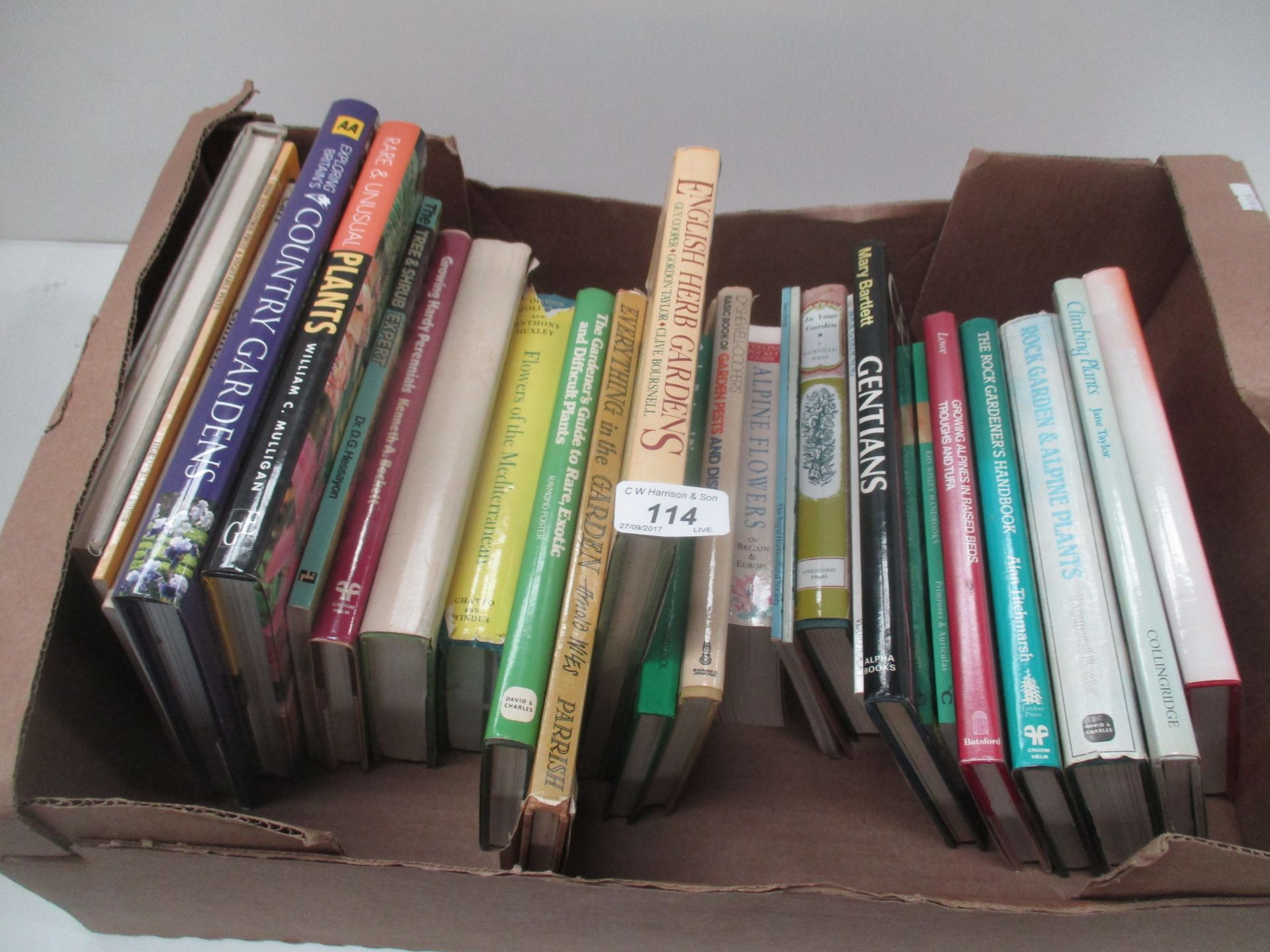 A box of assorted gardening books.