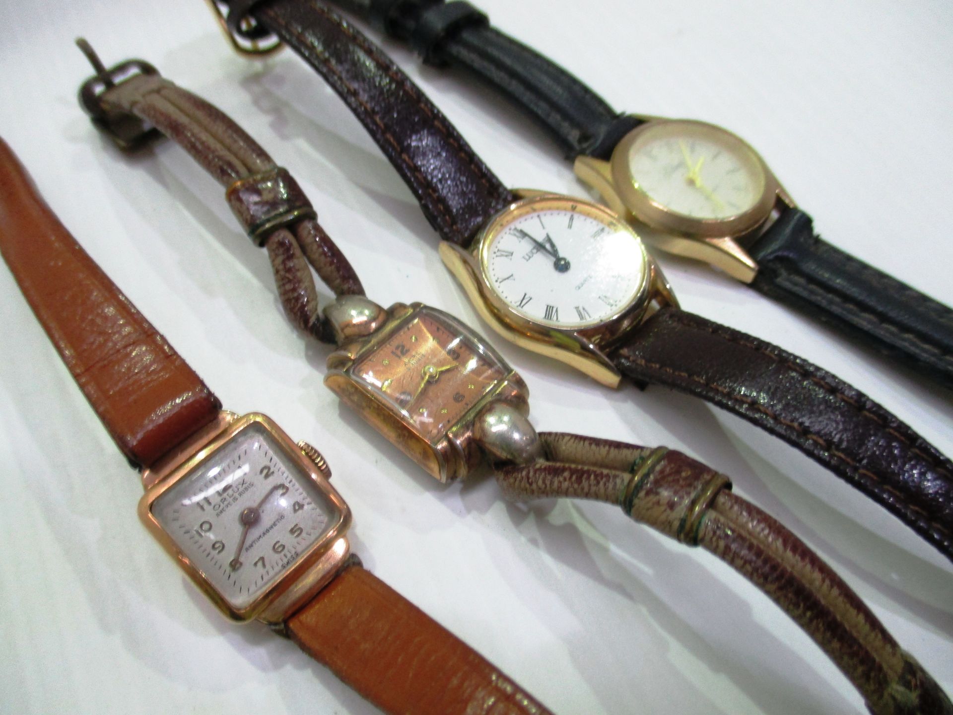 A ladies Orlux wristwatch with an 18ct gold case and a brown leather strap and 3 other assorted