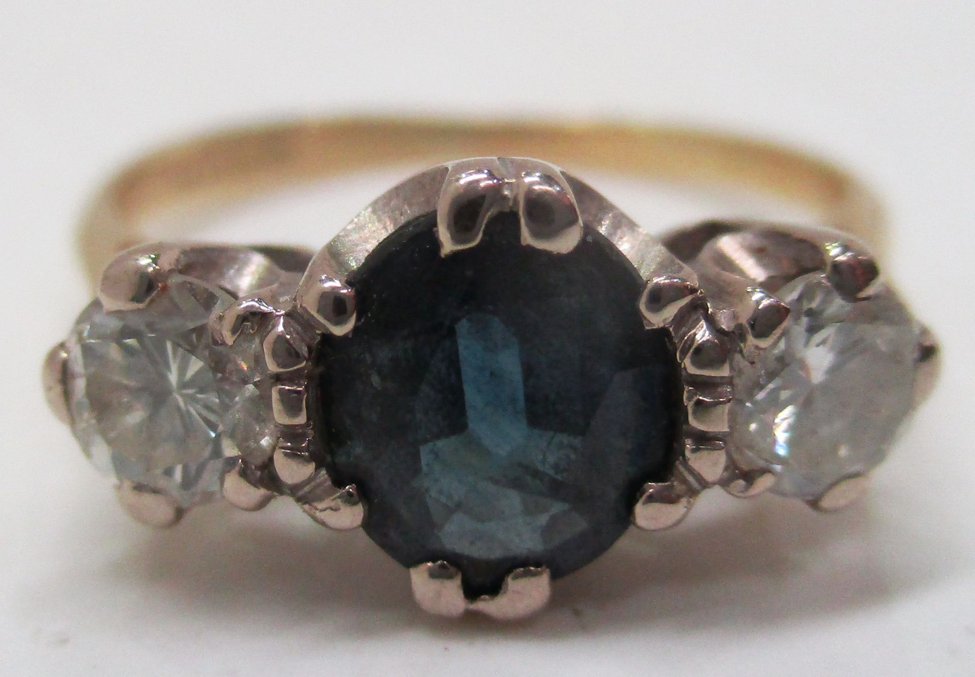 An 18ct gold ring set with large central sapphire stone and a diamond to either side (total approx