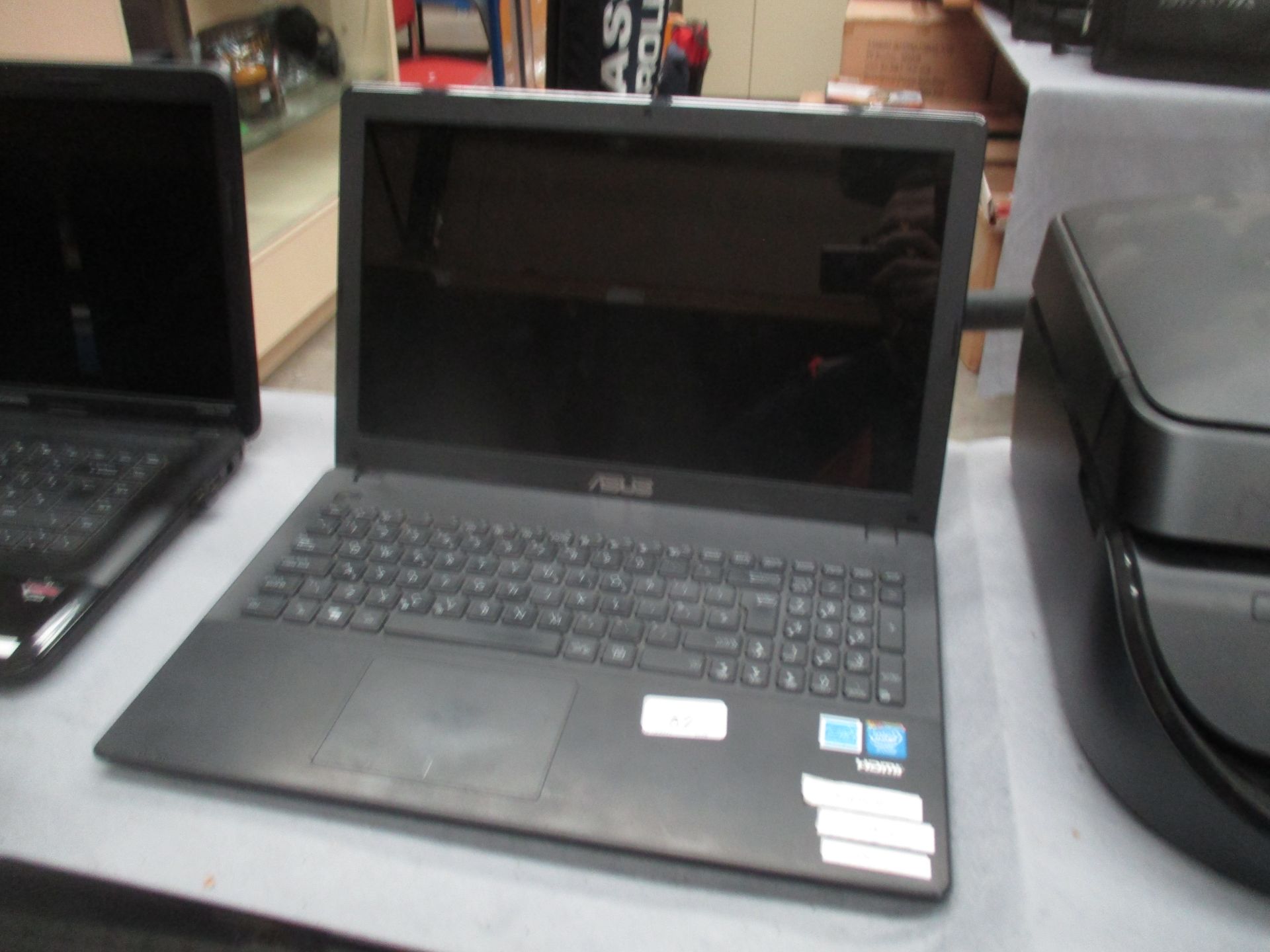 An ASUS F551M laptop computer with power lead