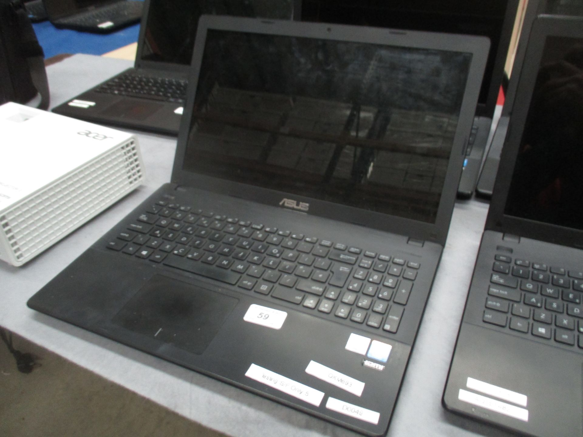 An ASUS X551M laptop computer with power lead