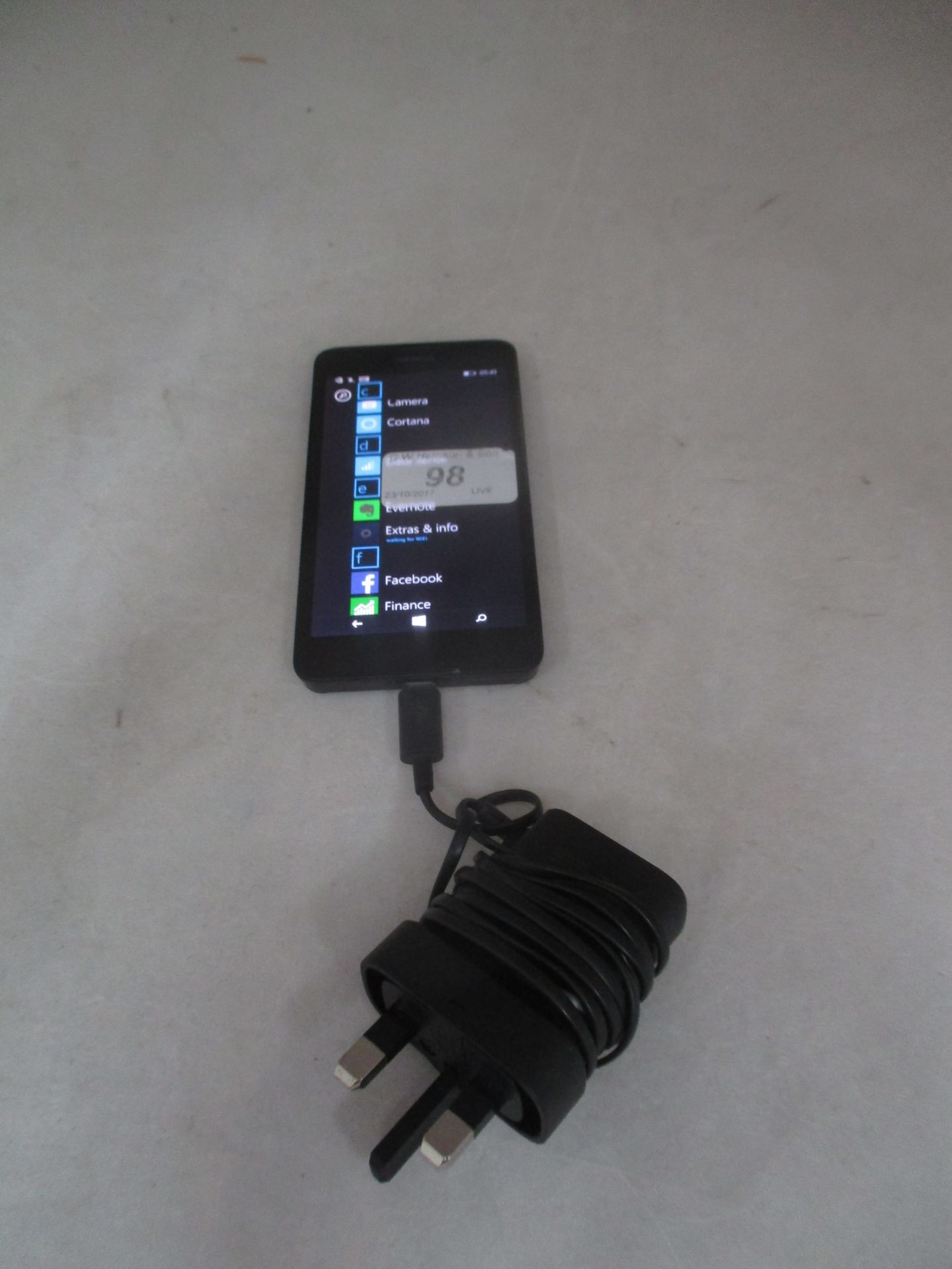 A Nokia Lumia RM-974 Microsoft mobile phone with charger