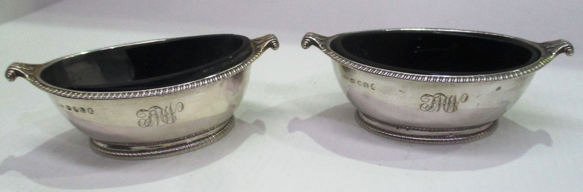 A pair of George III silver oval open salts, gadrooned border, foliate scroll handles,