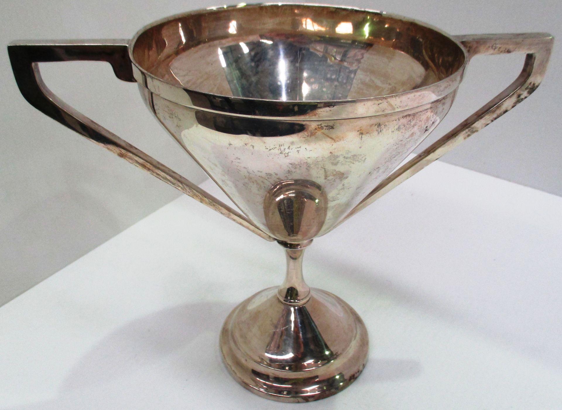 A silver two handled trophy cup on spreading circular pedestal base,