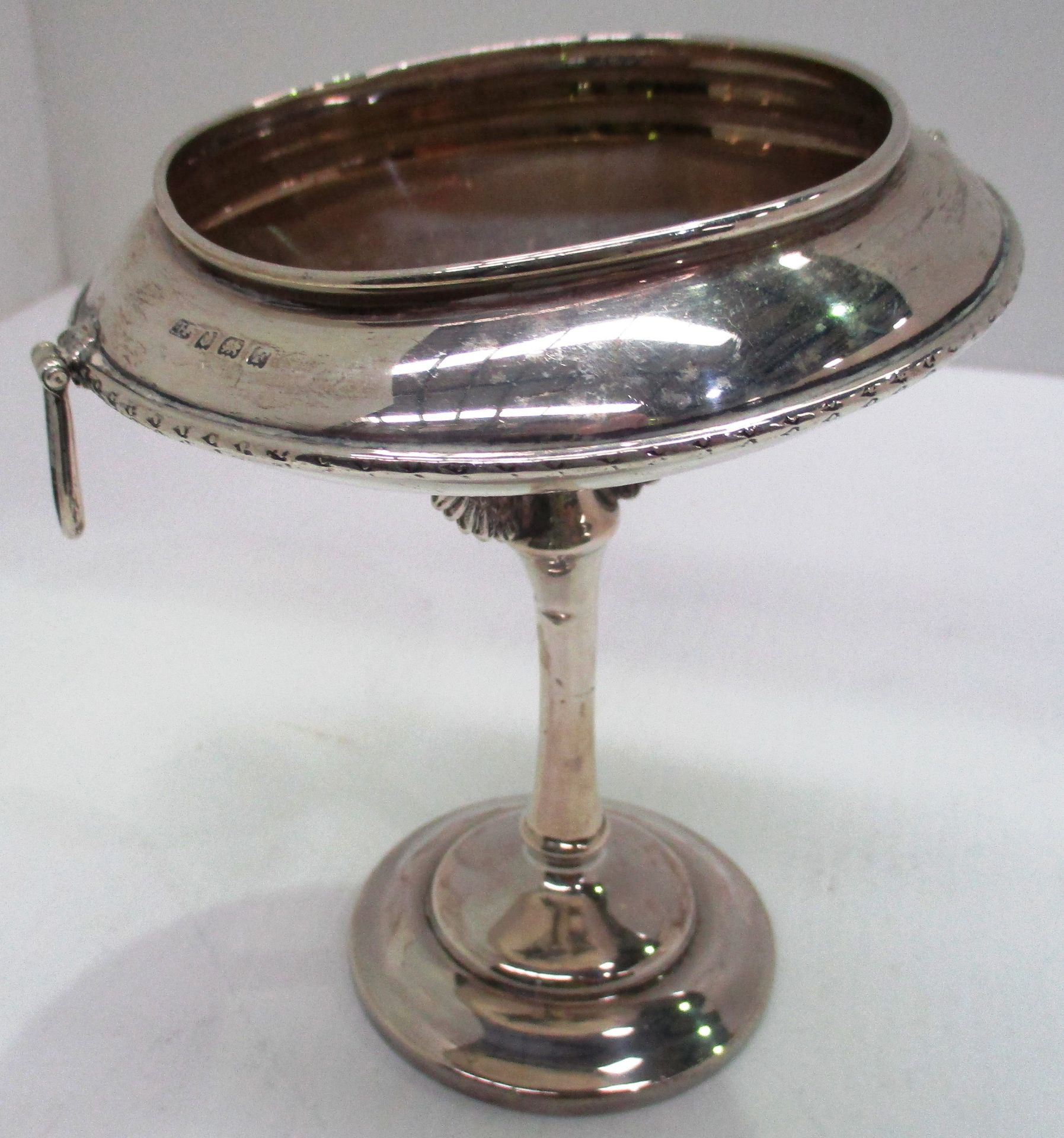 A silver two handled circular pedestal dish ornamented with pairs of cast wing brackets,