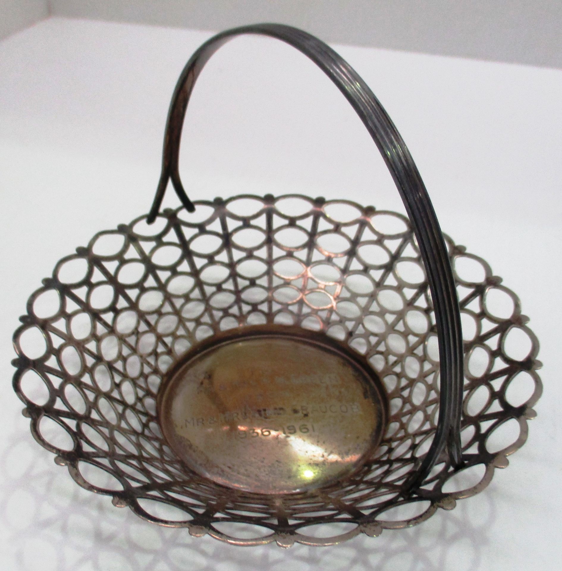 A small presentation silver circular basket with latticed base and reeded hoop handle made by