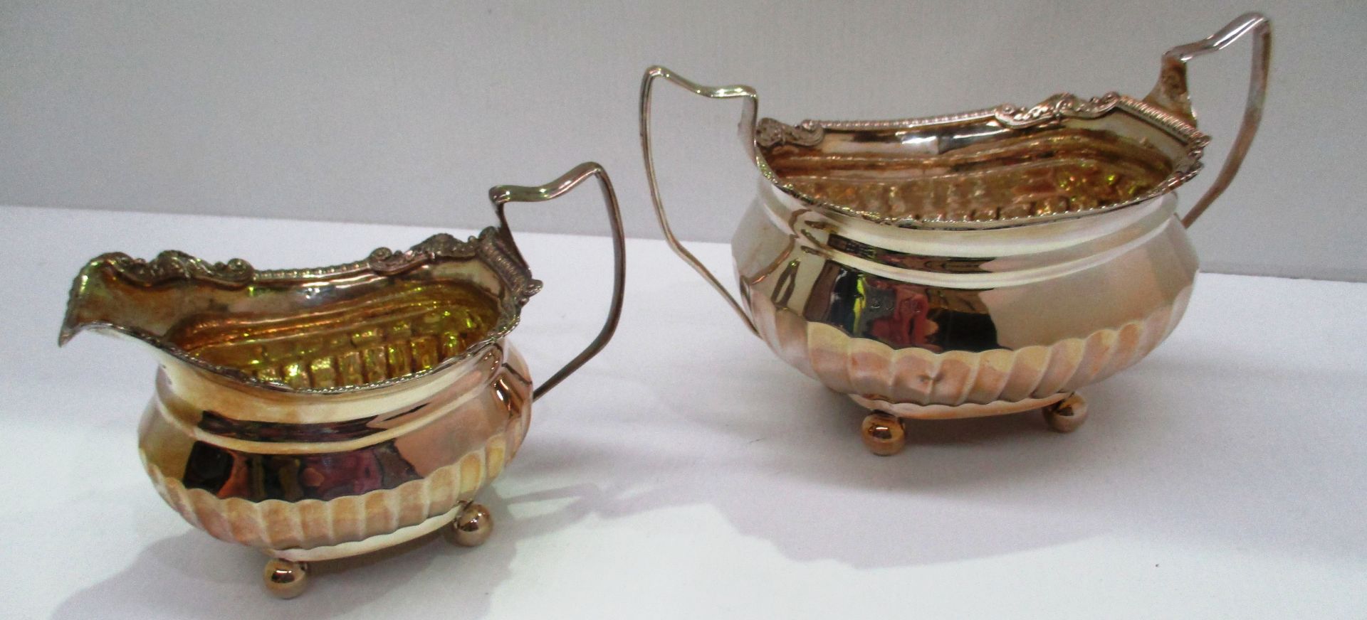 A silver two handled sugar basin semi-fluted and with cast border gilt interior made by Thomas