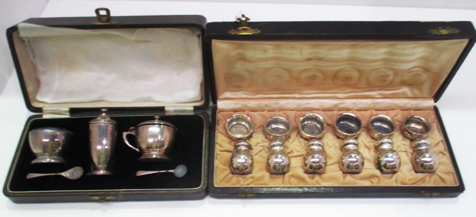 A set of three silver table condiments with spoons Birmingham 1941 in fitted case and a further set