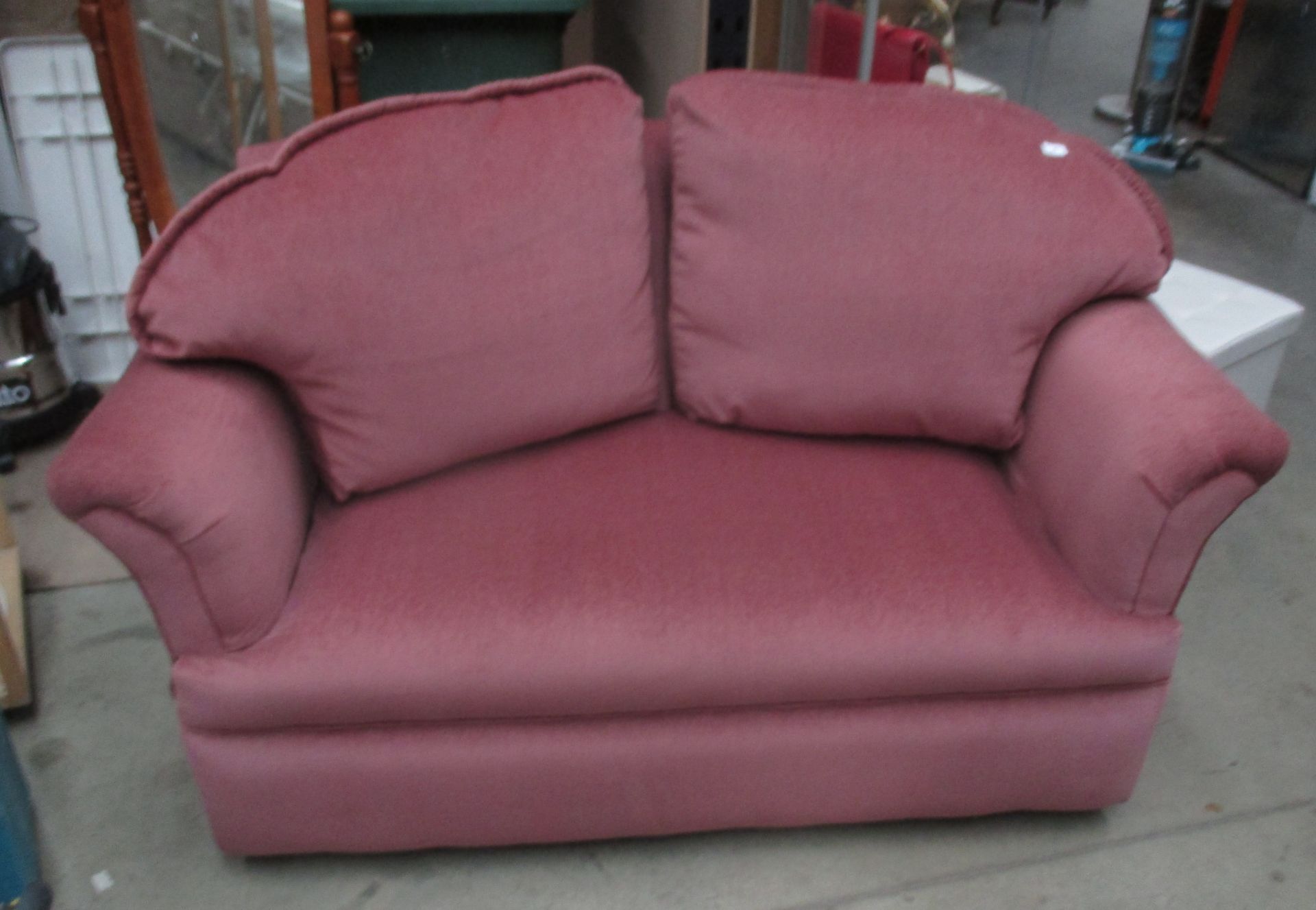 A pink upholstered two seater settee