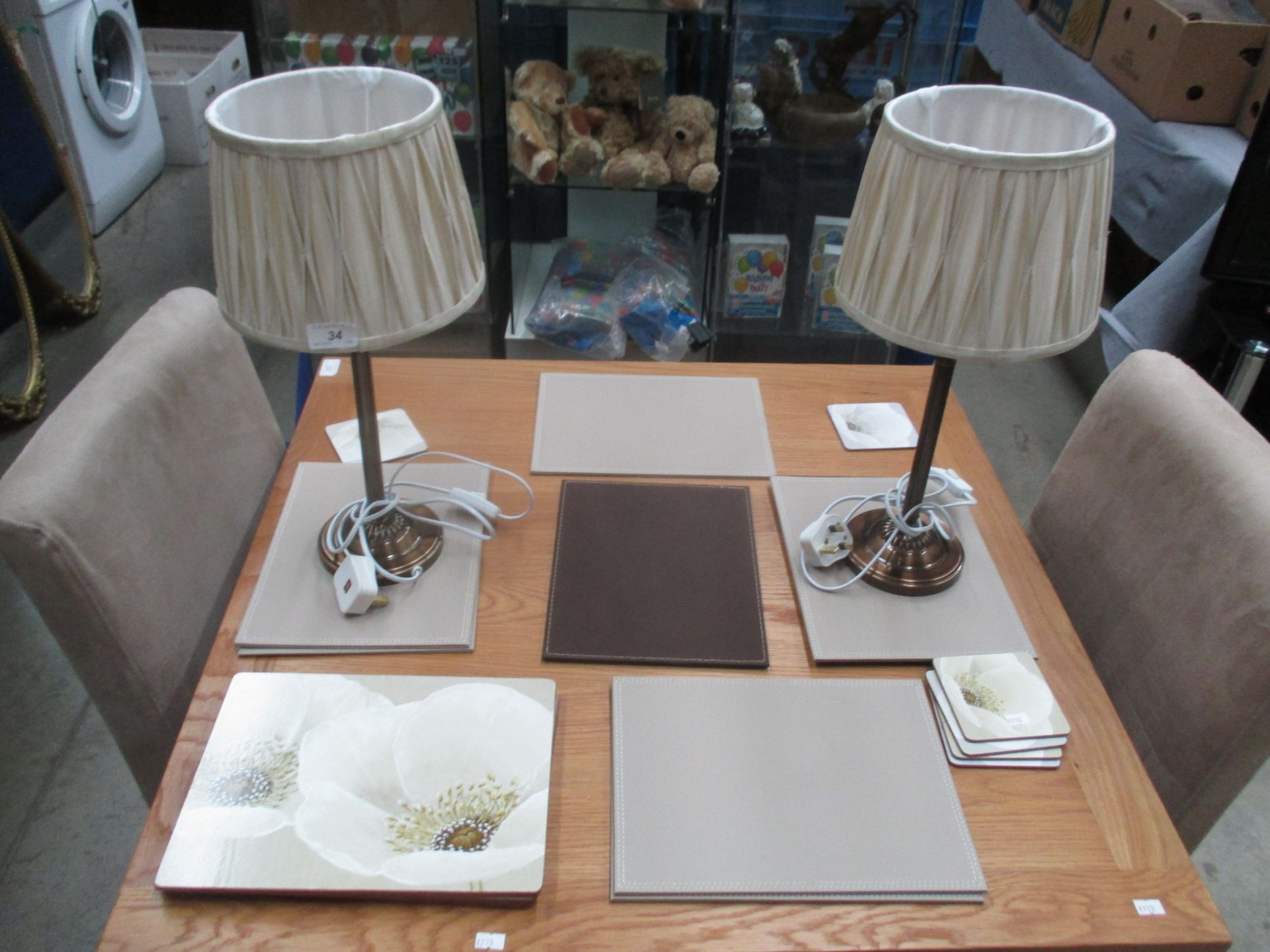 A pair of bronze effect table lamps and a quantity of table mats (some floral patterned)