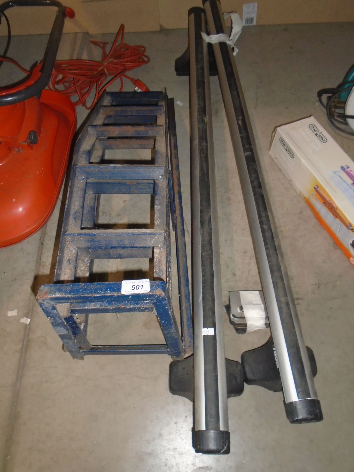 A pair of blue metal car ramps and a pair of Thule roof bars