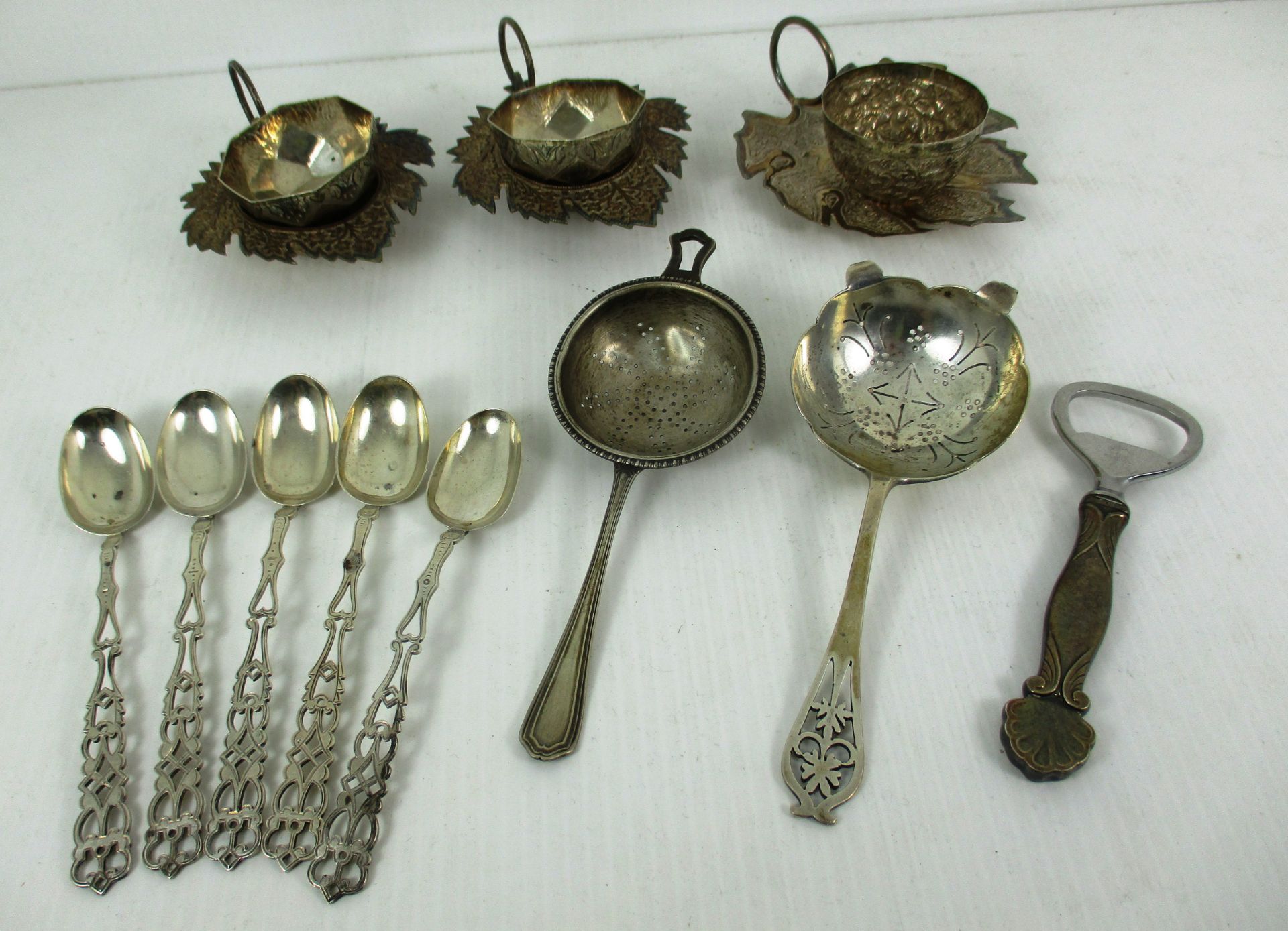 Five silver tea spoons, two silver tea strainers,