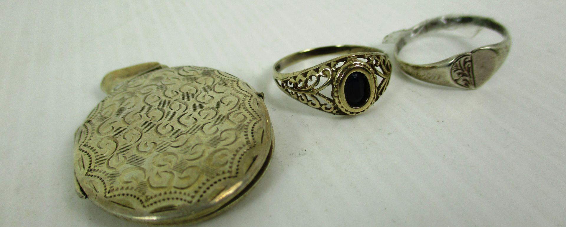A 9ct gold ring with pierced shoulders set with a dark blue/black stone,