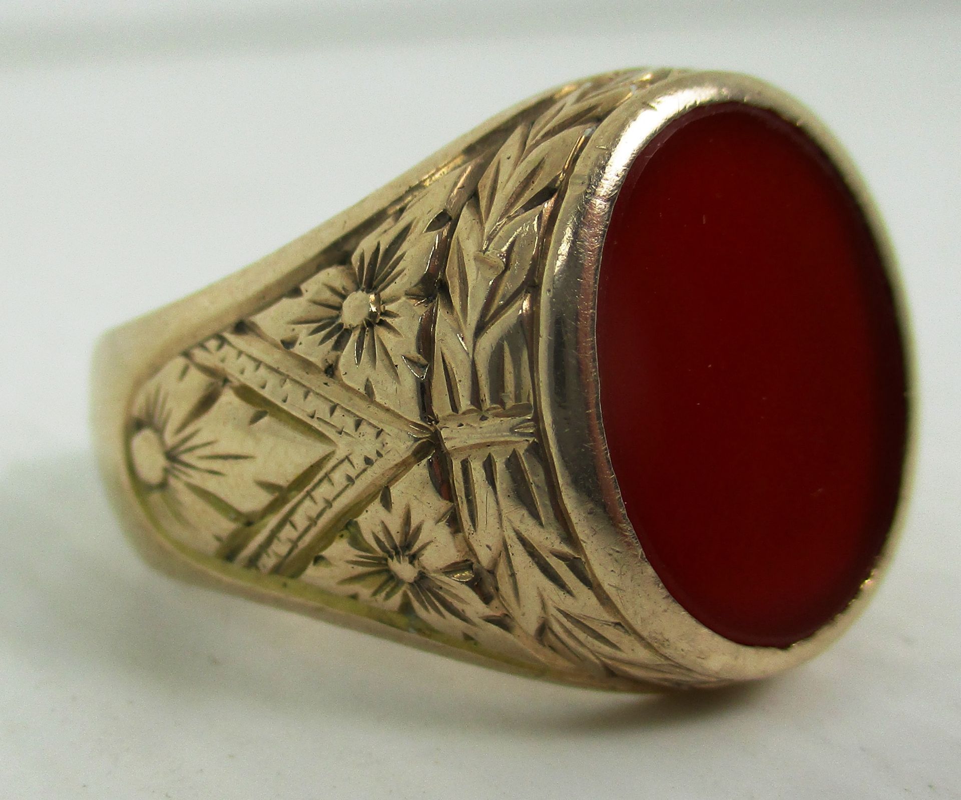 A gents signet ring with engraved decoration and red stone (no Hallmarks)
