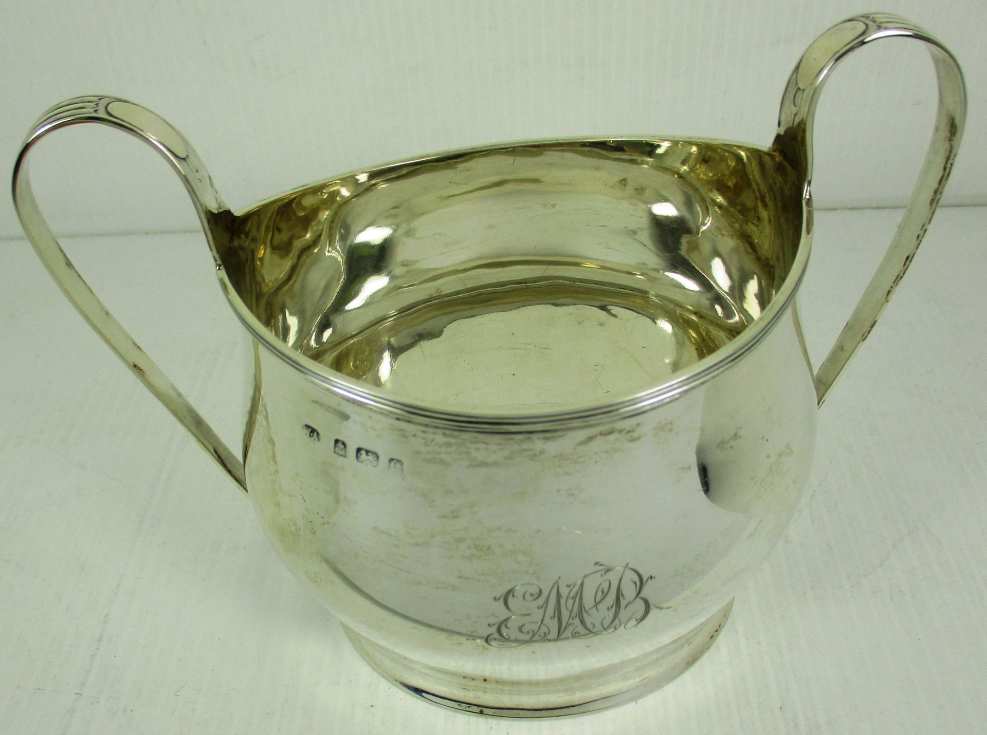 A silver two handled sugar bowl, with plain oval shaped bellied body,