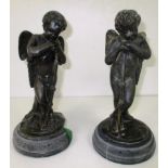 A pair of cast metal cherub figures on faux marble bases - as seen 25cm high