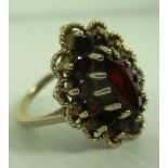 A 9ct gold cluster ring set with central oval red stone and flanked by smaller circular red stones