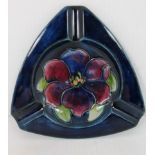 A triangular Moorcroft ashtray in cobalt blue gloss finish with clematis decoration (13.