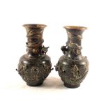 A pair of 19th Century Chinese Brass vases with raised dragon decoration,