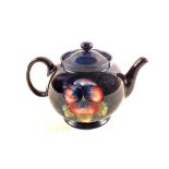 A Moorcroft Pansy pattern teapot on blue ground,