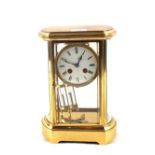 A French Brass four glass panel clock with mercury pendulum and enamel dial