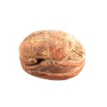 An Egyptian pottery scarab seal with seated figure of Osiris (base chip),