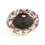 A circular dish with pink floral painting