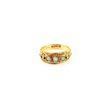 An 18ct Gold ring set with pierced scrollwork shoulders set with three small Opals and four small