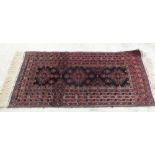 A Persian red ground rug,