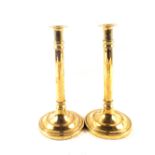 A pair of late 18th Century Brass candlesticks with cylindrical columns and wide circular bases,