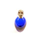 A blue glass scent bottle with white metal hinged owl stopper