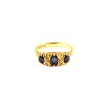 An 18ct Gold three Sapphire set ring interspersed with small Diamonds