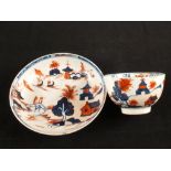 A Lowestoft red and blue doll's house pattern tea bowl and saucer,