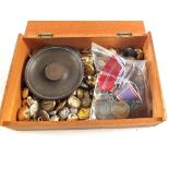 A wooden box containing various military buttons,